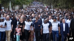 Rwanda's President Paul Kagame, center, gestures as he and first lady Jeannette Kagame, center-left, lead a "Walk to Remember" accompanied by Ethiopia's Prime Minister Abiy Ahmed, far left, Prime Minister of Belgium Charles Michel, second left, France's H