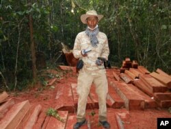 FILE - Chut Wutty stands on wooden planks of log in a jungle in Kampong Thom province, northern Phnom Penh, Cambodia, Feb. 6, 2012. Photo released by the Cambodian Center for Human Rights (CCHR).