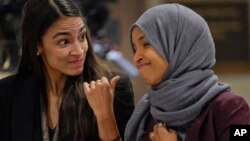 Anggota DPR AS dari faksi Demokrat, Alexandria Ocasio-Cortez (kiri) dan IIhan Omar berbincang di Gedung Capitol, Washington DC.