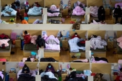 In this Feb. 17, 2020, photo released by Xinhua News Agency, patients infected with the coronavirus rest at a temporary hospital converted from Wuhan Sports Center in Wuhan in central China's Hubei Province.