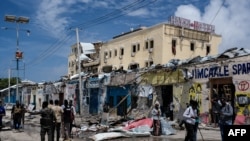 (FILES) Media report in front of destroyed building after a deadly 30-hour siege by Al-Shabaab jihadists at Hayat Hotel in Mogadishu on August 21, 2022.