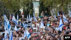 FILE —Family members, friends and supporters of hostages held in the Gaza Strip since the October 7 attack wave flags and hold images of those taken during a protest calling for their release outside the Prime Minister's office in Jerusalem on November 18, 2023.