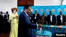 Cameroonian President Paul Biya casts his ballot while his wife Chantal Biya watches at a polling station during the presidential election in Yaounde, Cameroon, Oct. 7, 2018. 