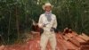 In this photo released by the Cambodian Center for Human Rights, environmentalist Chut Wutty stands on wooden planks in a jungle in Kampong Thom province, Cambodia, Feb. 6, 2012. He was fatally shot later in the year.