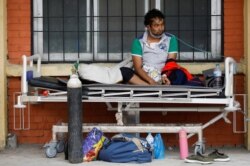 A patient receives oxygen as he waits outside the passage of a hospital due to a lack of free beds inside the hospital for coronavirus disease (COVID-19) patients, as the second major coronavirus wave surges in Kathmandu, Nepal, May 10, 2021.