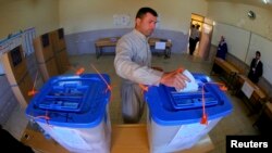 An Iraqi Kurdish man casts his vote into a ballot box at a polling station during voting for Iraqi parliamentary election in Arbil, capital of the autonomous Kurdistan region, about 350 km (217 miles) north of Baghdad, April 30, 2014.