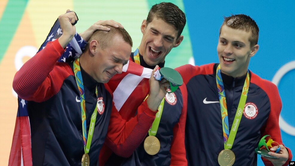 Caeleb Dressel, es animado por Michael Phelps y Ryan Held, luego de ganar el 4X100 Libre de la natación olímpica.