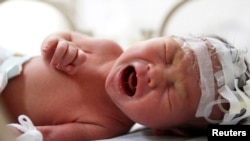 An abandoned newborn baby cries in an incubator after he was rescued from a sewage pipe at a hospital in Jinhua, Zhejiang province, China, May 28, 2013.