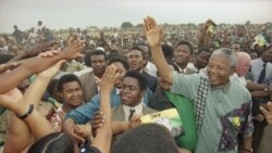 FILE - African National Congress President Nelson Mandela, right, waves to the gathered crowd at Jouberton Township stadium, South Africa, Jan 30, 1994.