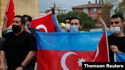 Demonstrators holding Azeri and Turkish flags shout slogans during a protest against Armenia near the Consulate of Azerbaijan in Istanbul, Turkey, Sept. 29, 2020.