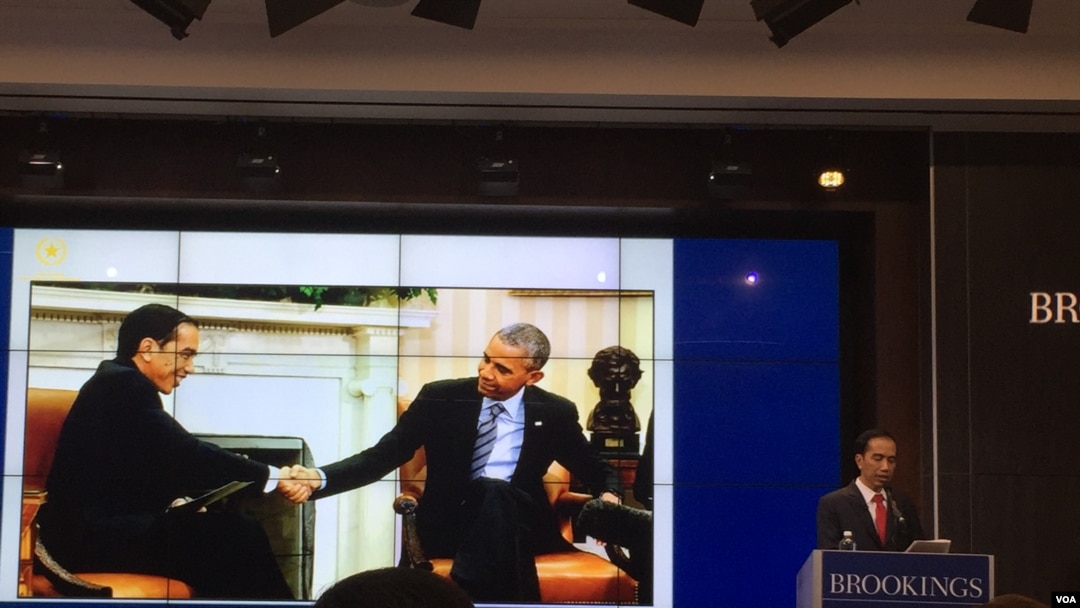 Dengan latar belakang foto ia bersalaman dengan Presiden Barack Obama, Presiden Joko Widodo berbicara dalam forum di Brookings Institution, Washington. (foto: Priyo Pujiwasono)