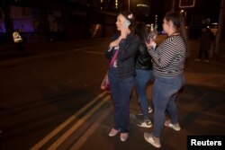 Concert goers react after fleeing the Manchester Arena in northern England where U.S. singer Ariana Grande had been performing in Manchester, Britain, May 22, 2017. REUTERS/Jon Super - RTX373FZ