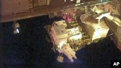 In this frame grab from NASA Television, astronauts Scott Kelly, upper right, and Kjell Lindgren, bottom, perform maintenance outside the International Space Station, Oct. 28, 2015.