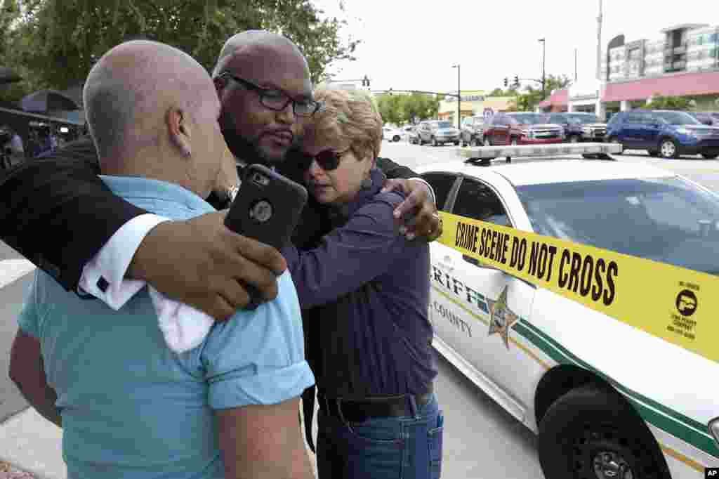 Terry DeCarlo, executive director of the LGBT Center of Central Florida, left, Kelvin Cobaris, pastor of The Impact Church, center, and Orlando City Commissioner Patty Sheehan console each other after a shooting involving multiple fatalities at a nightclu