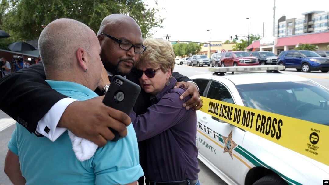 Terry DeCarlo, executive director of the LGBT Center of Central Florida, left, Kelvin Cobaris, pastor of The Impact Church, center, and Orlando City Commissioner Patty Sheehan console each other after a shooting at a nightclub in Orlando, Fla., June 12, 2016.
