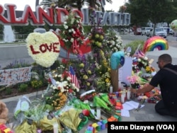People leave flowers and other items at a makeshift vigil outside the Orlando Regional Medical Center, which is close to where the mass shooting occurred at the Pulse gay nightclub early Sunday in Orlando, Florida, June 14, 2016.