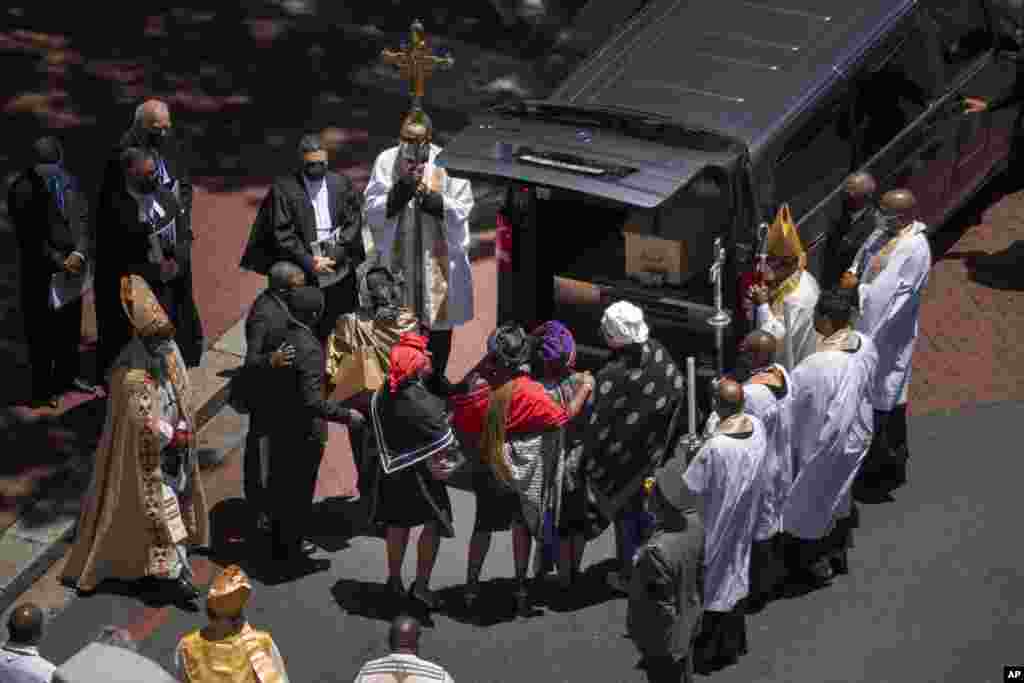 Relatives hug in front of the casket carrying the remains of Anglican Archbishop Emeritus Desmond Tutu after it was put in a hearse following his funeral service at the St. George&#39;s Cathedral in Cape Town, South Africa, Jan.1, 2022.