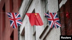 FILE - Chinese and British flags fly in London's Chinatown, Britain, Oct. 19, 2015. 