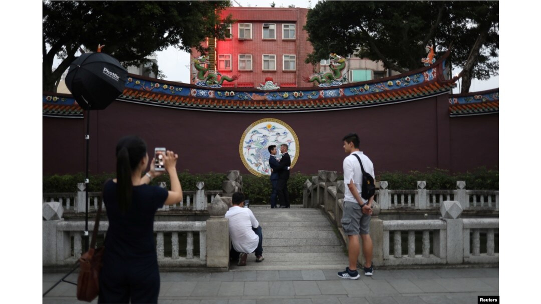 John Sugden and Kao Shaochun have their pre-wedding photos taken by Austin Haung, 32, as Lin Chinxuan, right, 29, stands by, in Taipei, Taiwan, Nov. 11, 2018.