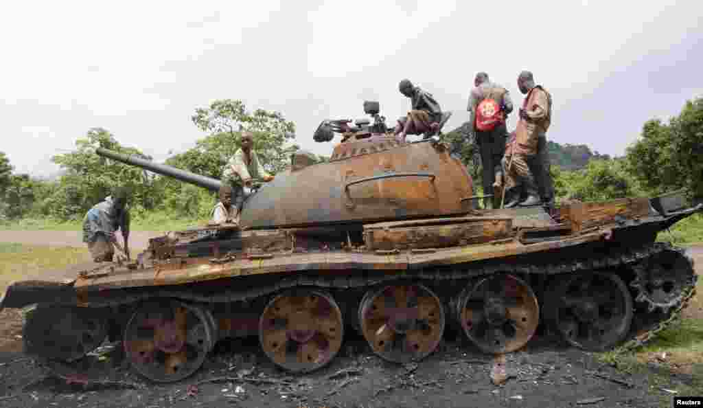 Anak-anak Kongo bermain tank yang ditinggalkan oleh para pemberontak M23 yang menyerah di kota Kibumba, Republik Demokratik Kongo. 