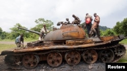 Des enfants jouant sur un tank abandonné par le M23