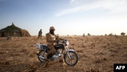 FILE - A soldier of the Burkina Faso Army sits on his motorcycle during a patrol in Burkina Faso, November 9, 2019. Two soldiers were killed by a homemade bomb in southeast Burkina Faso on October 11, 2021.