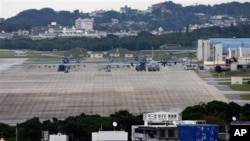 In this Dec. 17, 2009 photo, military airplanes and helicopters sit on the airstrip at Futenma Marine Corps Air Station surrounded by houses in Ginowan, Okinawa, Japan.