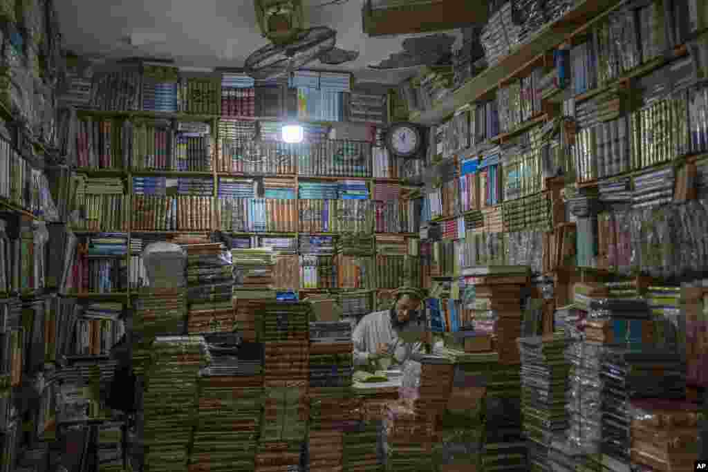 A bookshop owner repairs a book in Herat, Afghanistan.