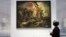 A woman looks at Eugene Delacroix 's painting, "Liberty Leading the People" (28 July 1830) during media day on the eve of the inauguration of the Le Louvre Lens Museum, December 3, 2012. 