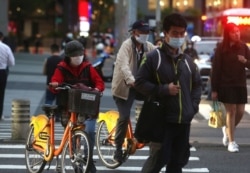 FILE - People wear face masks to protect against the spread of the coronavirus in Taipei, Taiwan, March 31, 2020.