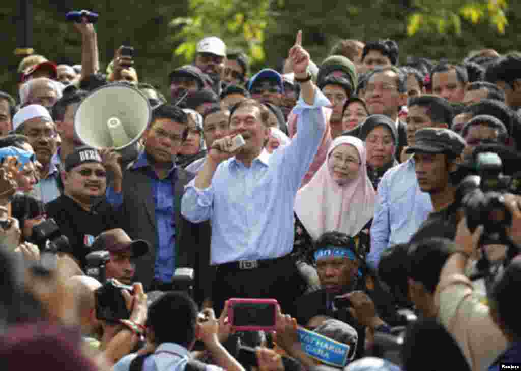 Malaysia's opposition leader Anwar Ibrahim (C) talks to his supporters while flanked by his wife Wan Azizah Wan Ismail after the verdict of his sodomy trial was announced in Kuala Lumpur January 9, 2012.