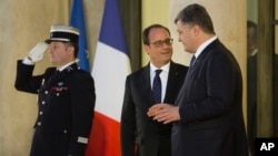 Ukrainian President Petro Poroshenko, right, and French President Francois Hollande speak at the Elysee Palace after meeting in Paris to discuss new efforts to bring peace to eastern Ukraine, Oct. 2, 2015.