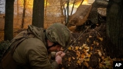 FILE - A serviceman of the 13th Brigade of the National Guard of Ukraine fires a Giatsint-B gun towards Russian positions near Kharkiv, Ukraine, on Nov. 6, 2024. 