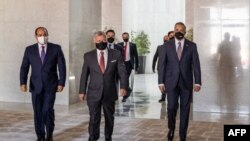 A picture released by the Jordanian Royal Palace on Aug. 25, 2020, shows Jordanian King Abdullah II, center, arriving with Egyptian President Abdel Fattah al-Sissi, left,and Iraqi Prime Minister Mustafa Kadhimi ahead of a summit in the capital Amman.