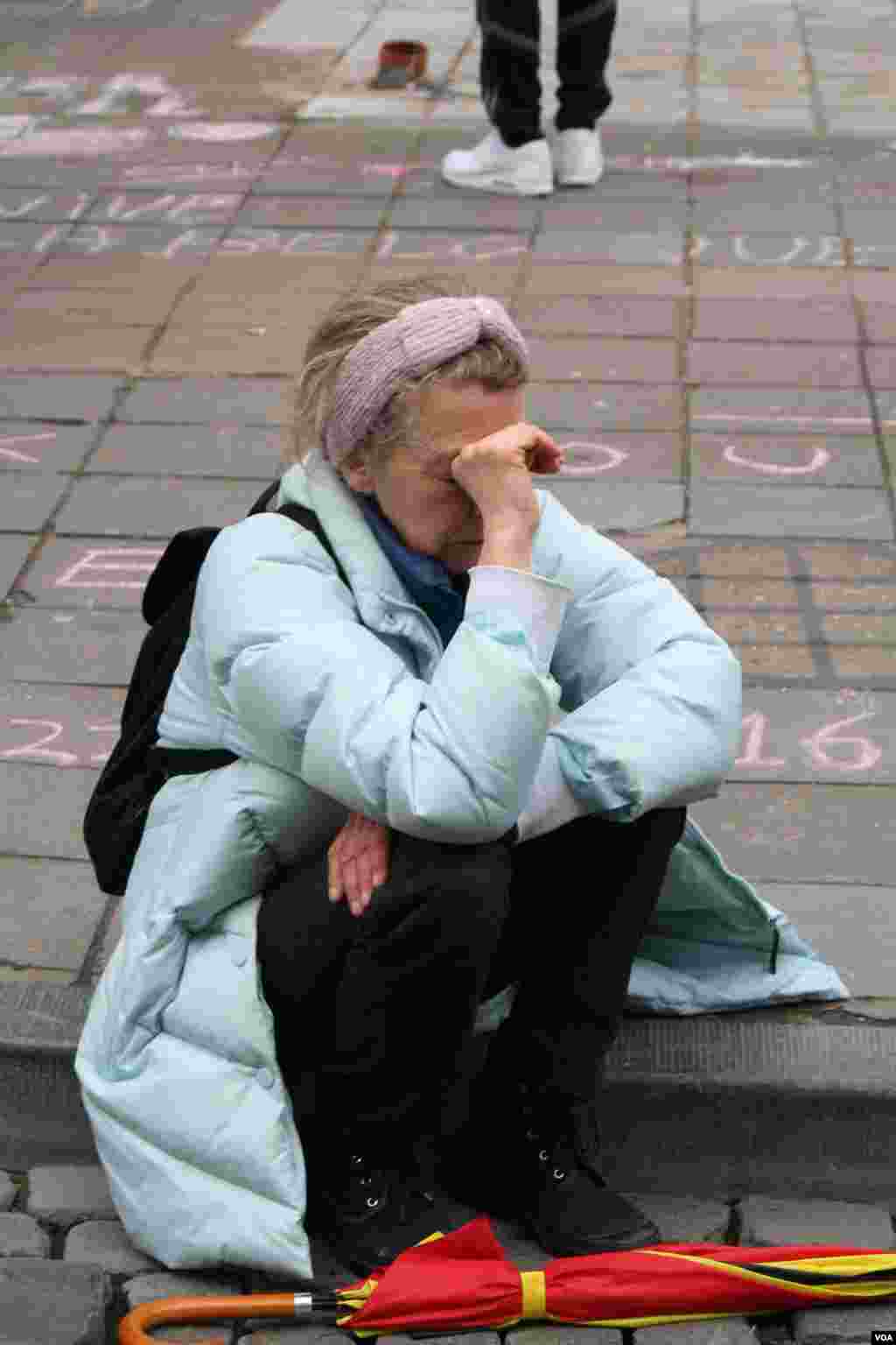 A woman weeps after observing a moment of silence in honor of the dead and injured in Brussels, Belgium. (H. Murdock / VOA)