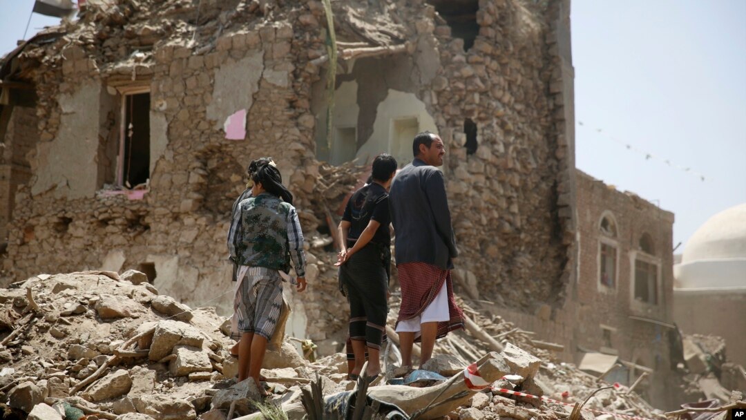 Warga berdiri di antara reruntuhan bangunan akibat serangan udara pimpinan Saudi di Sana'a, Yaman (foto: dok).