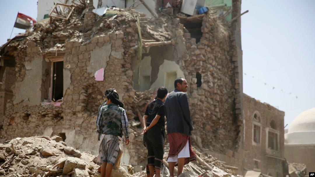 Orang-orang memperhatikan rumah yang rusak akibat serangan udara yang dipimpin Arab Saudi di kota tua Sana'a, Yaman, 19 September 2015.