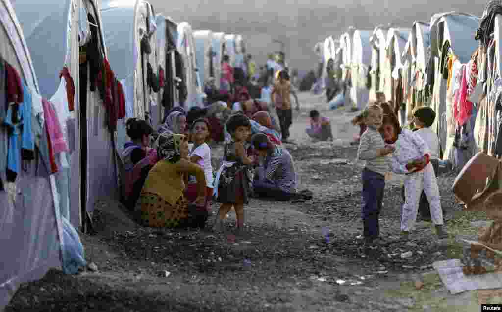 Kurdish refugees from the Syrian town of Kobani sit in front of their tents in a camp in the southeastern town of Suruc, Sanliurfa province, Oct. 5, 2014.