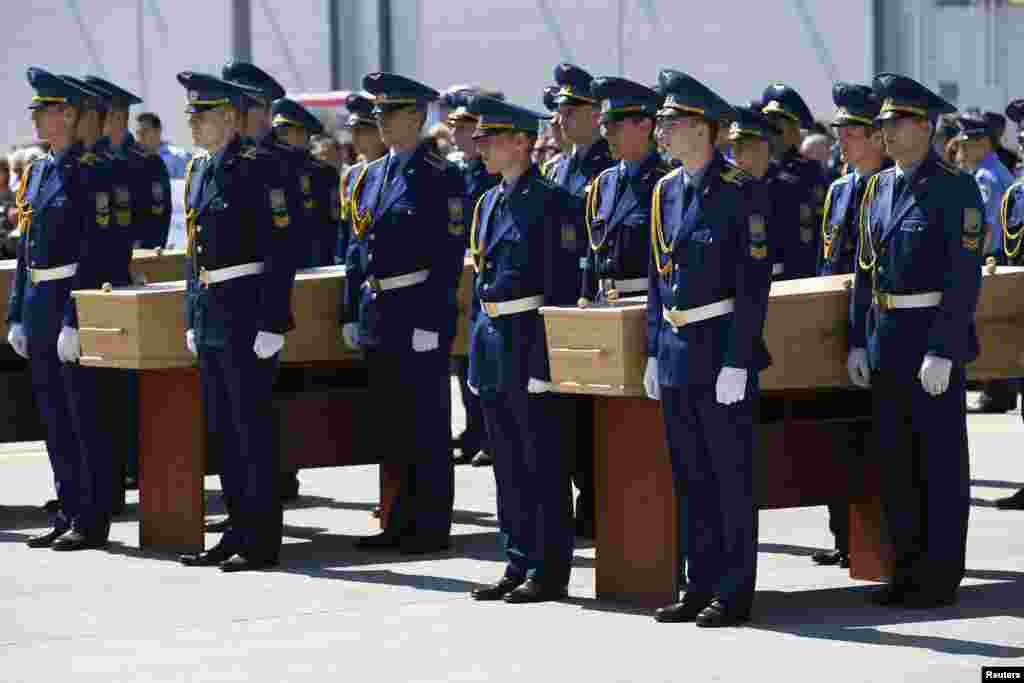 Para tentara ambil bagian dalam upacara korban-korban jatuhnya pesawat Malaysia Airlines MH17 sebelum dimasukkan ke dalam pesawat menuju Belanda, di bandar udara Kharkiv, Ukraina (23/7). (Reuters/Gleb Garanich)