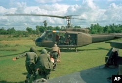 U.S. paratroopers carry a wounded man on a stretcher into a waiting helicopter in Vietnam, May 7, 1966.