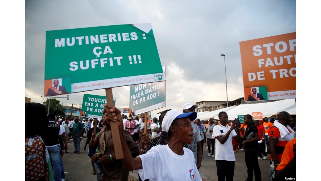 A partisan of the ruling party RDR (Rally of the republicans) holds a placard during a rally against the mutiny close to the military headquarters in Abidjan, Ivory Coast, May 13, 2017. The placard reads, "Mutinies: it's enough."