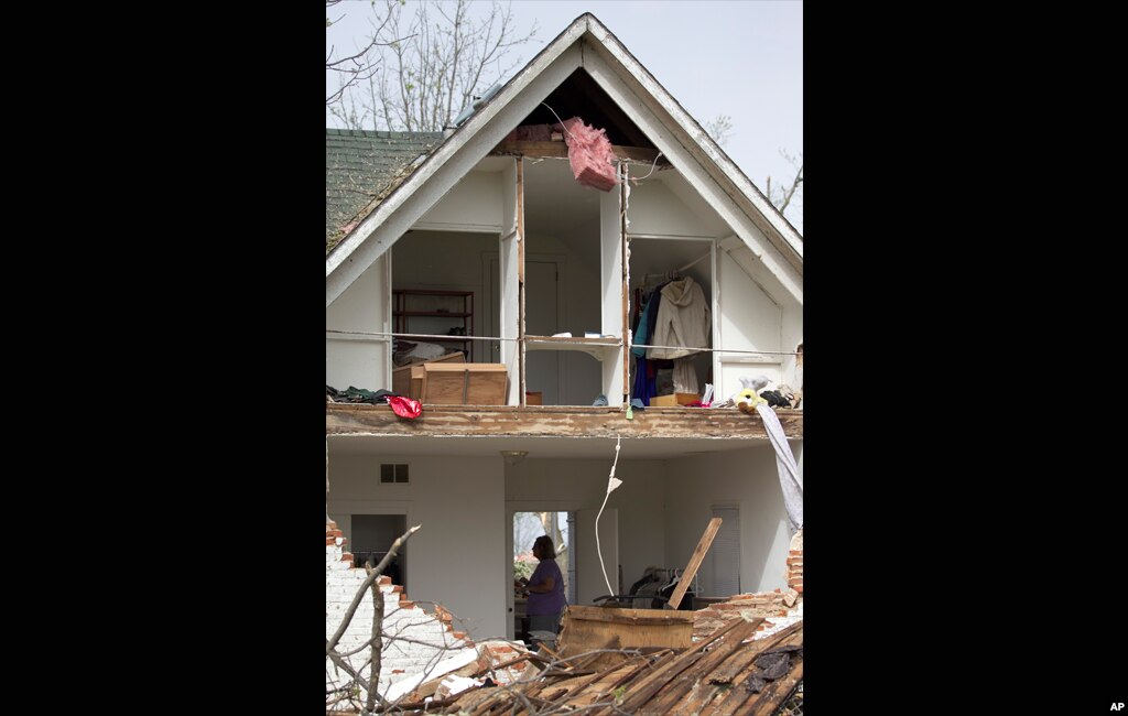 A woman is framed in the doorway of a damaged home in Thurman, Iowa April 15, 2012. Iowa emergency officials said a large part of the town in the western part of the state was destroyed, possibly by a tornado, but no one was injured or killed. Fremont Cou