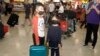 资料照：戴着口罩的儿童从武汉抵达悉尼机场。（2020年1月23日）
