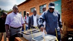 In this 2010 file photo, Burundian president Pierre Nkurunziza, right, casts his vote at a polling station in his hometown of Mumba in Ngozi province, northern Burundi. (AP Photo/Sylvain Liechti)