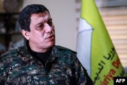 FILE - Mazloum Kobani, commander-in-chief of the Syrian Democratic Forces (SDF), speaks during an interview in the countryside outside the northwestern Syrian city of Hasakah, in a province of the same name, Jan. 24, 2019.