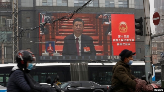 A giant screen shows Chinese President Xi Jinping attending the opening session of the National People's Congress (NPC) at the Great Hall of the People, in Beijing, China March 5, 2021. (REUTERS/Tingshu Wang)