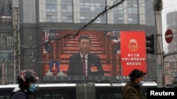 北京街頭的大屏幕顯示中國領導人習近平在參加全國人大會議的開幕式。 （2021年3月5日）