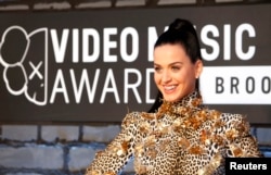 Singer Katy Perry shows off her bejeweled teeth on arrival for the 2013 MTV Video Music Awards in New York, Aug. 25, 2013.