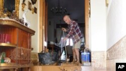 A man cleans his house affected by floods in Valencia, Spain, Oct. 30, 2024.