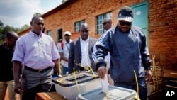 Burundian president Pierre Nkurunziza, right, casts his vote at a polling station in his hometown of Mumba in Ngozi province, northern Burundi. 